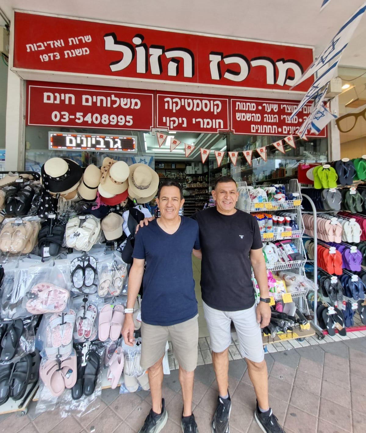 האחים ממשפחת חכם בכניסה לחנות מרכז הזול